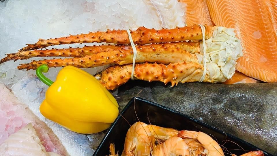 Eine Krabbe, eine Garnele und eine Paprika liegen auf dem Eis.