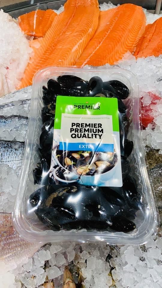 Ein Plastikbehälter mit Muscheln steht auf Eis.