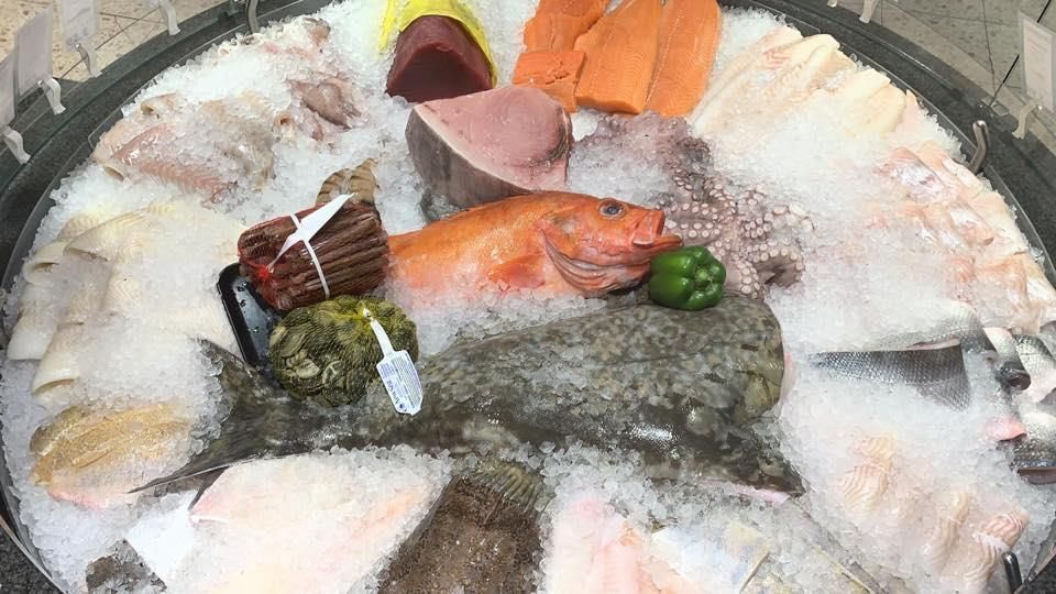 In einem Eimer liegen verschiedene Fische auf Eis.