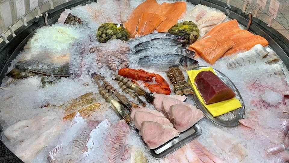 In einem Eimer werden verschiedene Meeresfrüchte auf Eis präsentiert.