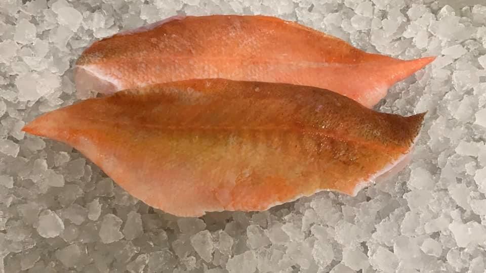 Zwei Fischstücke liegen auf dem Eis.