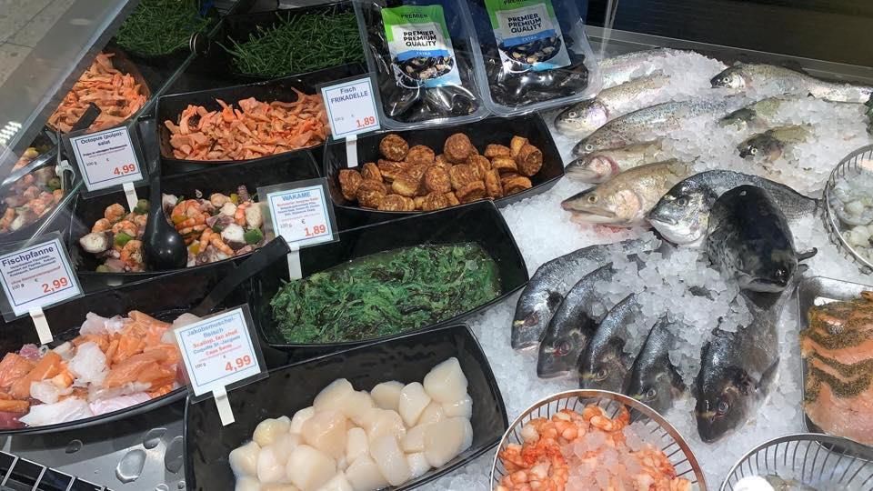 In einem Geschäft werden verschiedene Meeresfrüchte auf Eis präsentiert.