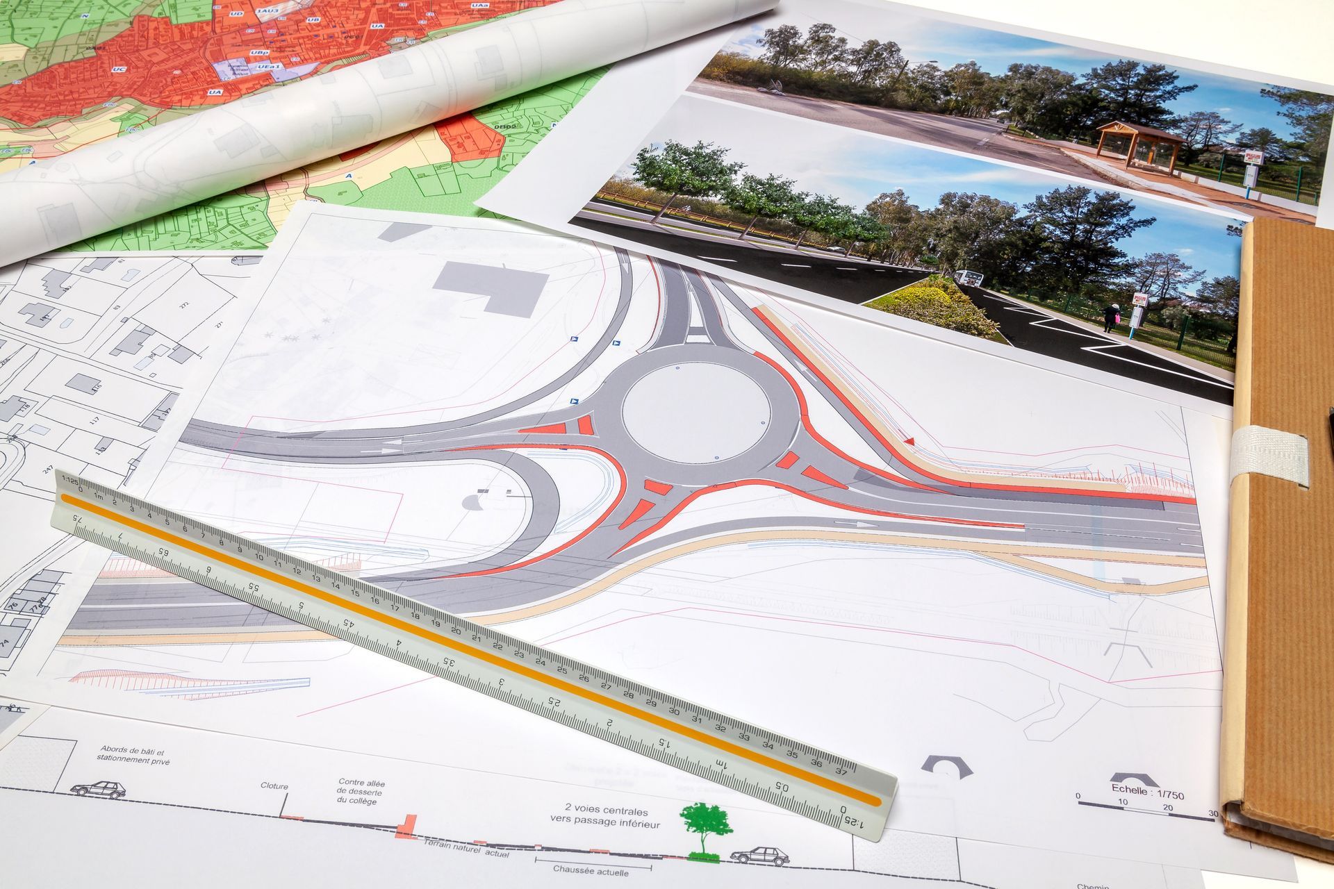Plan architectural de site avec un rond-point, une règle et des photos de référence paysagères sur un bureau
