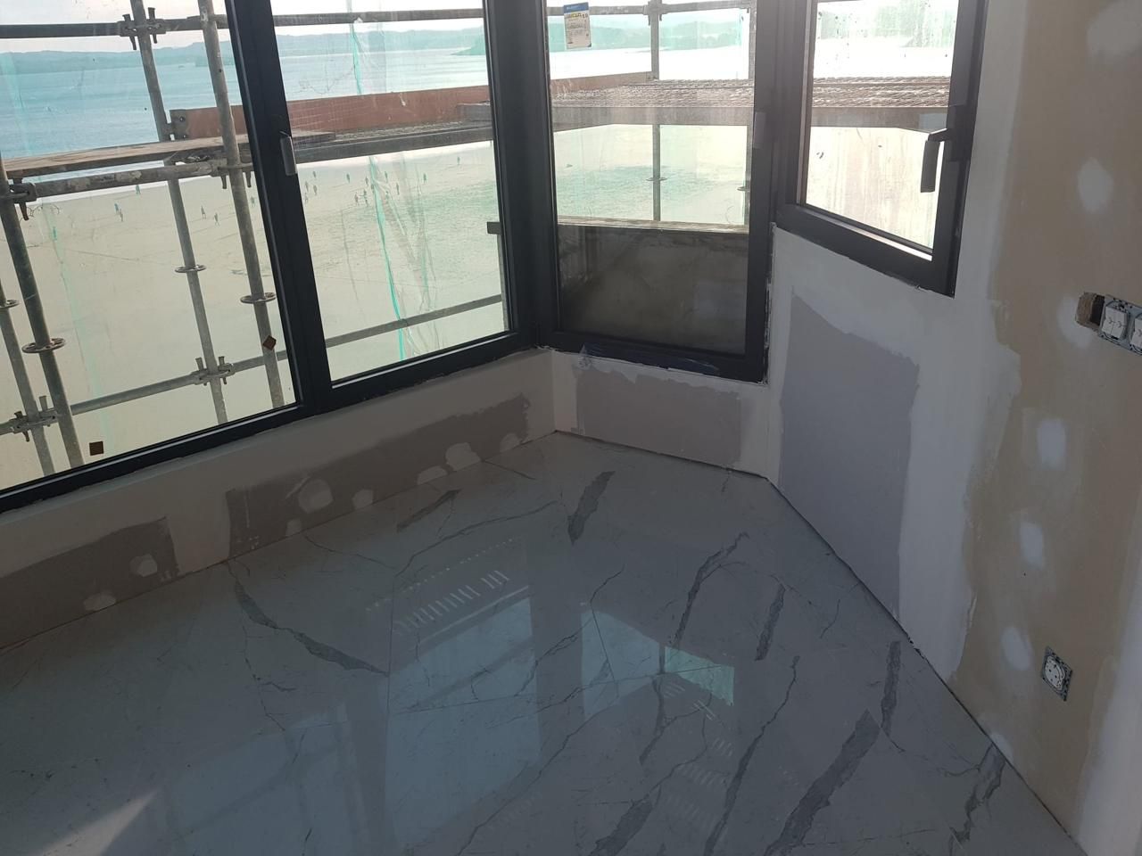 Una habitación con suelo de mármol y muchas ventanas.