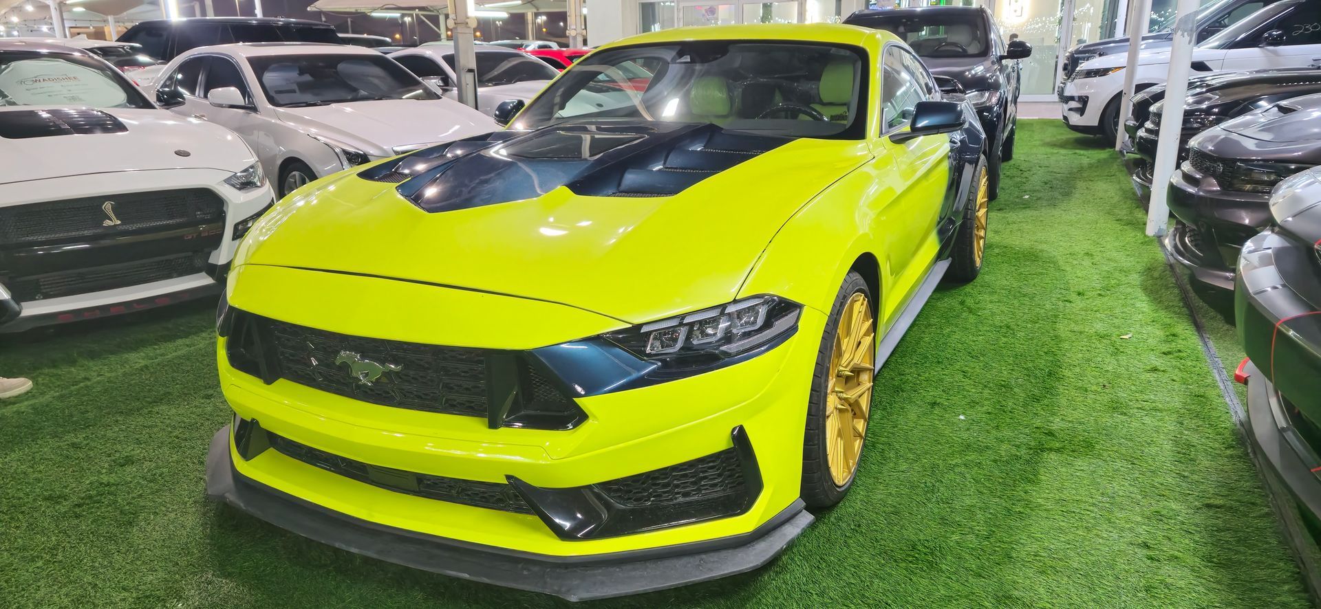 Un Chevrolet Camaro ZL1 blanco está estacionado en una sala de exposición.