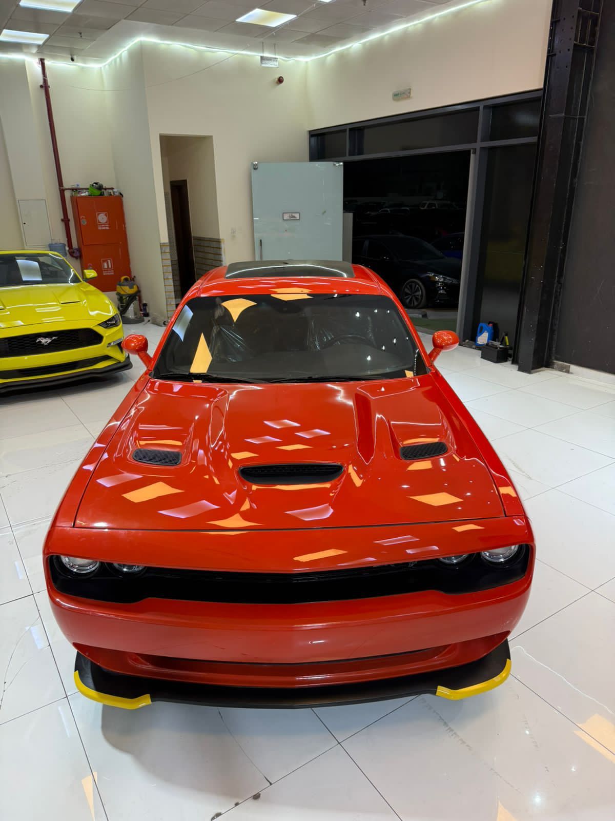 Un Ford Mustang rojo está estacionado en un garaje.