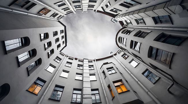 Mirando hacia arriba a un edificio con muchas ventanas.