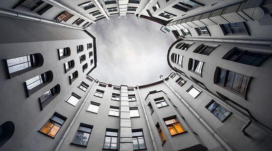 Mirando hacia arriba a un edificio con muchas ventanas.