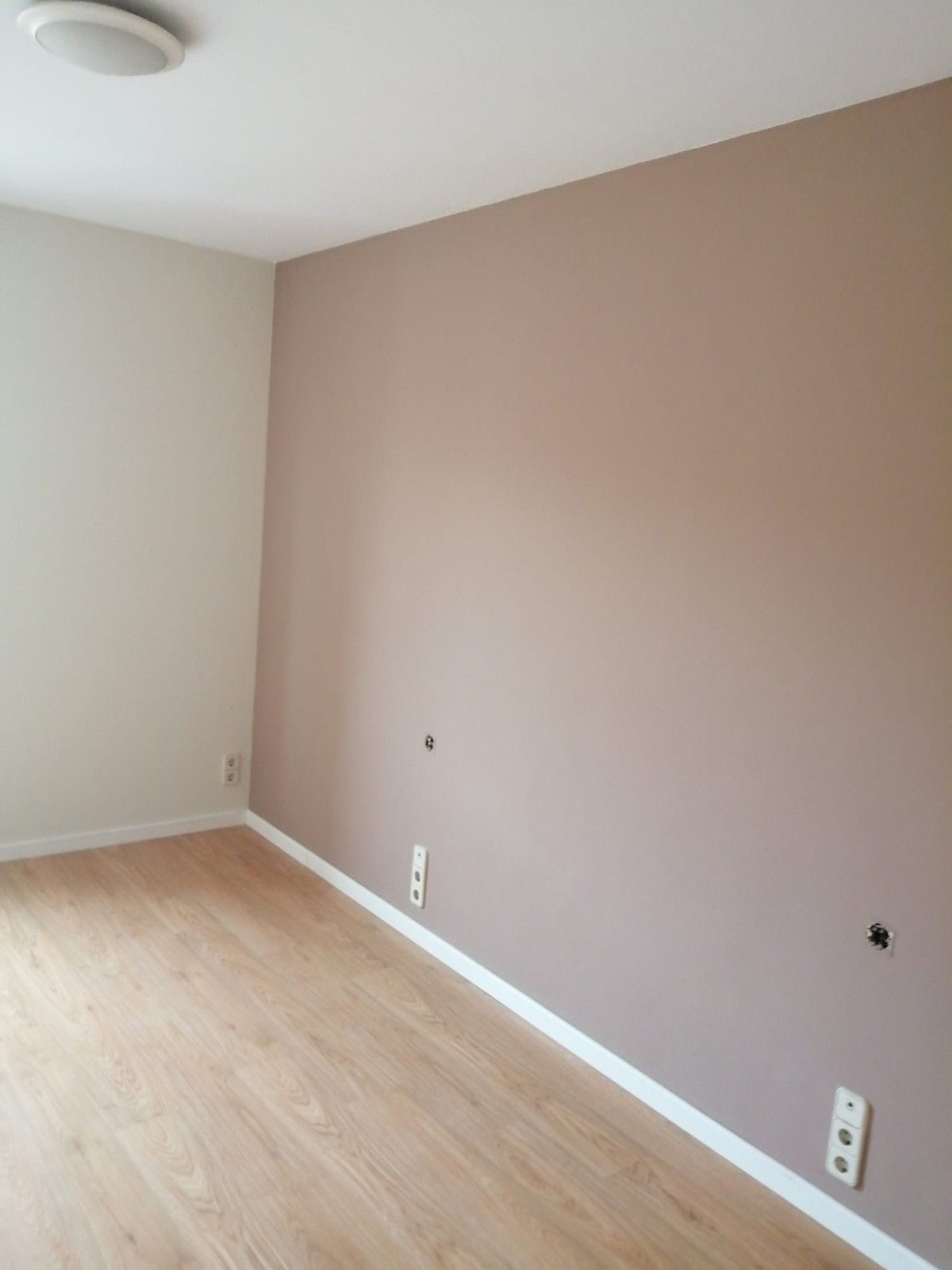 Piscina azul brillante en el patio trasero, junto a un patio con un cubo y herramientas en primer plano.