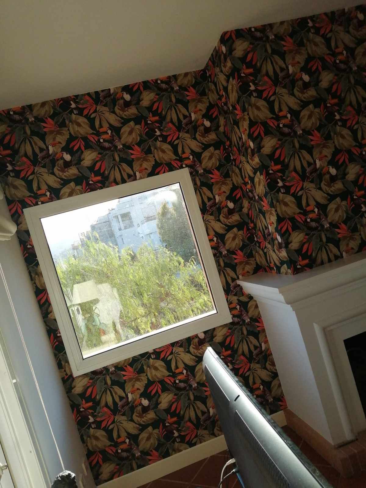 Vista interior inclinada de papel tapiz floral, espejo que refleja los árboles 