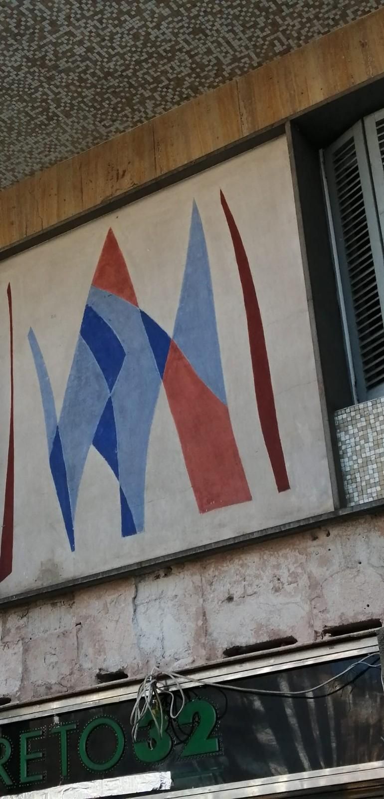 Logotipo abstracto rojo y azul en un letrero de edificio sobre la fachada de una tienda.