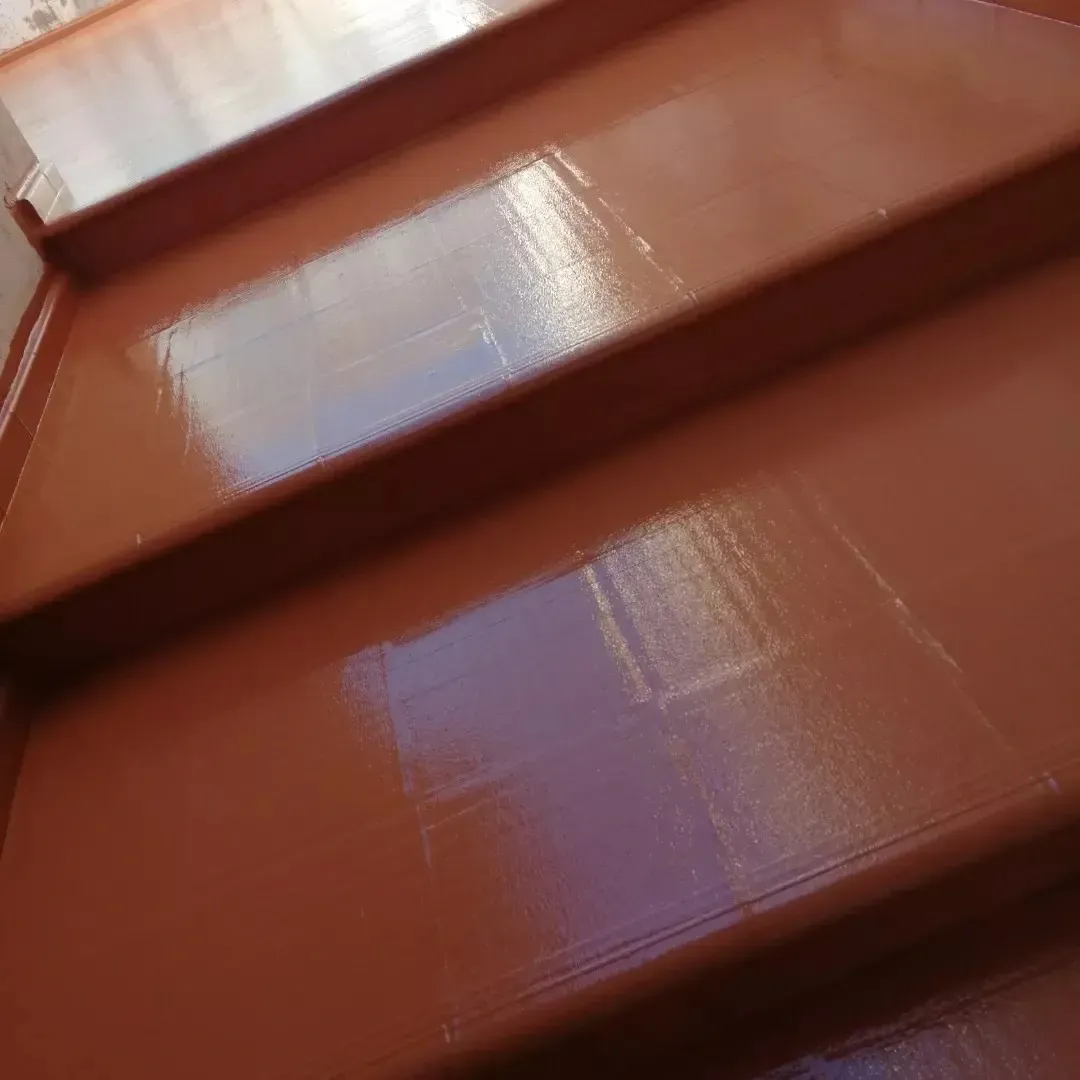 Primer plano de escalones pintados de un brillante color marrón rojizo con una barandilla blanca en la parte superior.