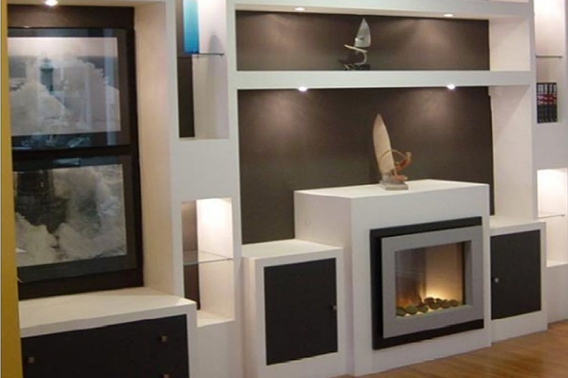 Moderna chimenea blanca empotrada con detalles en negro, estantes y obras de arte