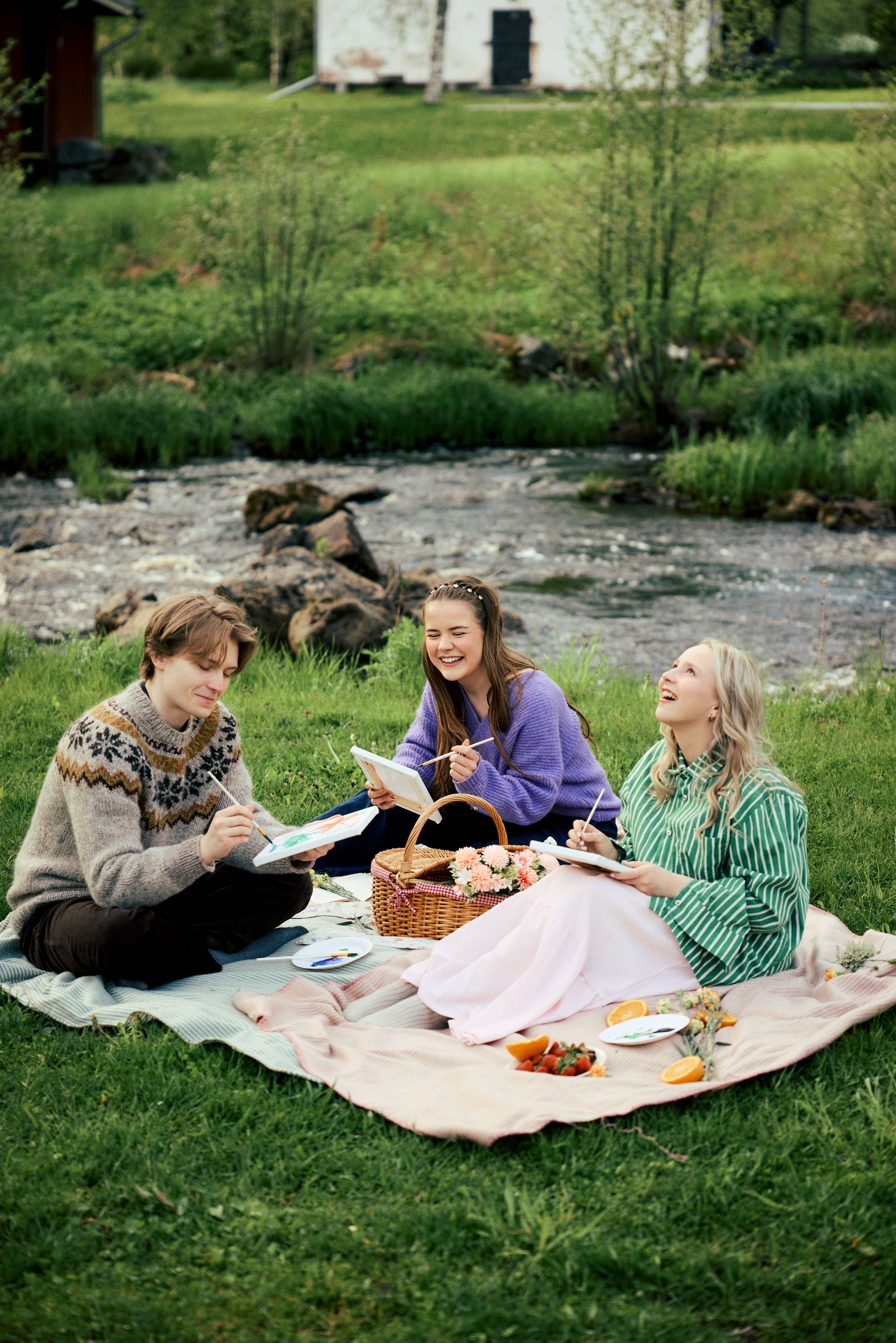 Infosta saat ostettua itsellesi maalaussetin! Kaksi naista ja poika maalaavat piknikillä satakuntalaisen Leineperin ruukin kauniissa miljöössä