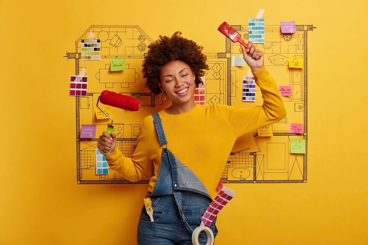 Une femme heureuse devant son projet de peinture intérieure