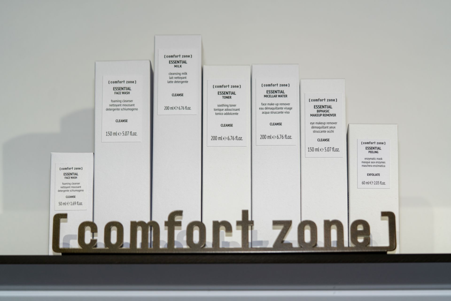 Eine Reihe weißer Kisten auf einem Regal mit einem Schild mit der Aufschrift „Komfortzone“