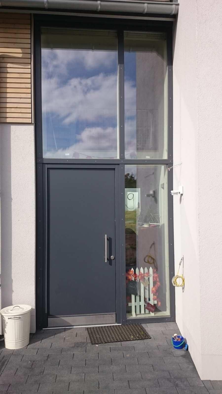 Eine große Tür mit vielen Fenstern an einem Gebäude.