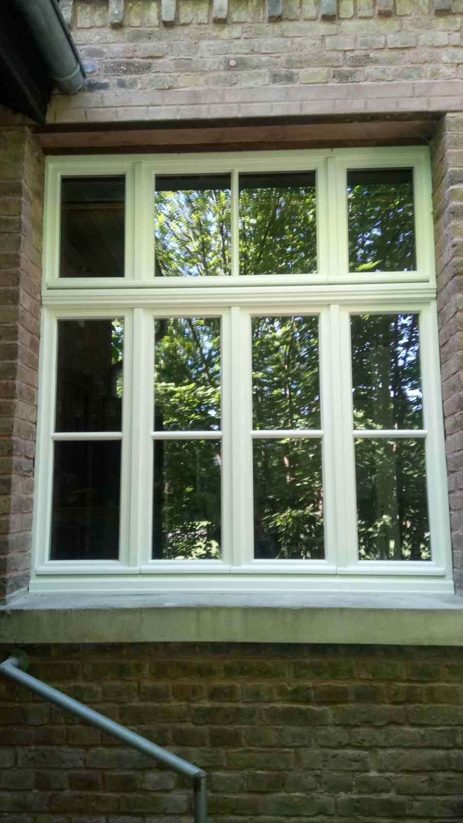 An der Seite eines Backsteingebäudes befindet sich ein weißes Fenster.