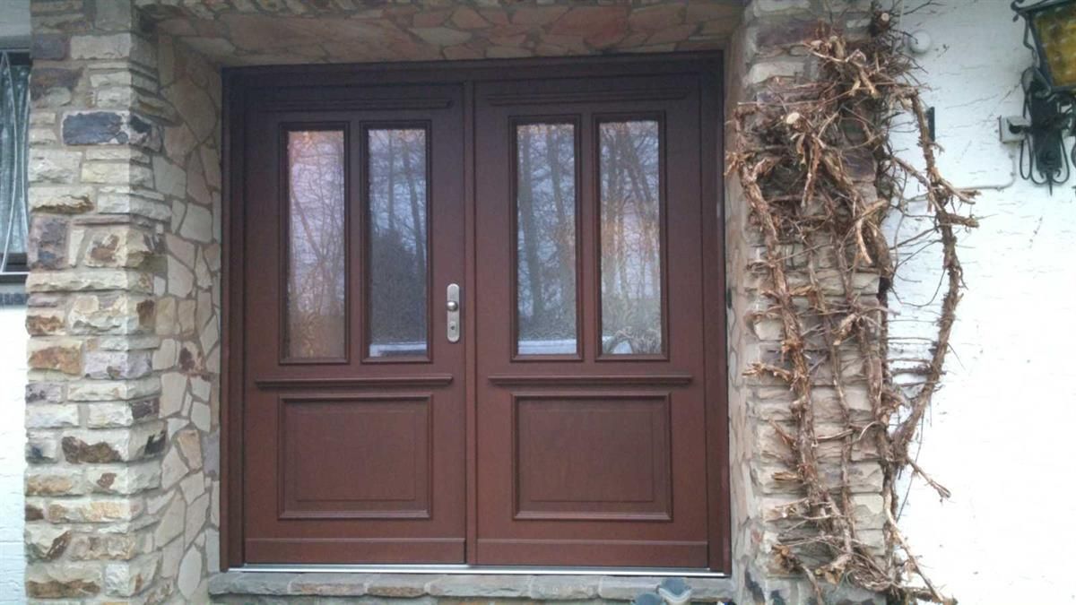 Vor einem Backsteingebäude befindet sich eine Holztür.