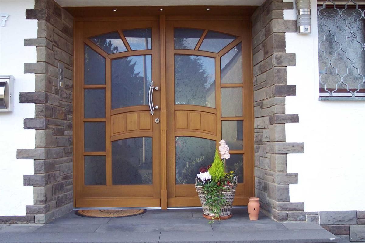 Die Haustür eines Hauses mit einer Topfpflanze davor