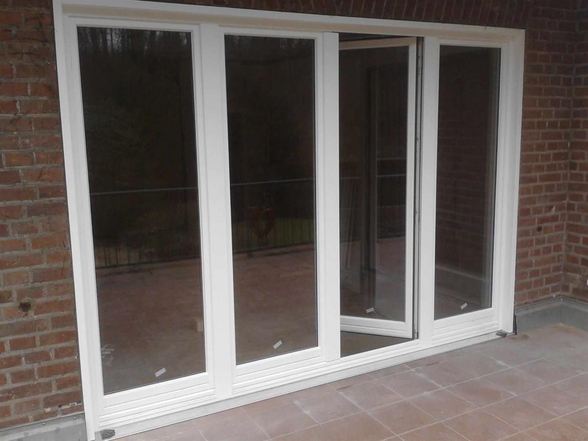 Eine weiße Glasschiebetür mit einer Ziegelwand im Hintergrund