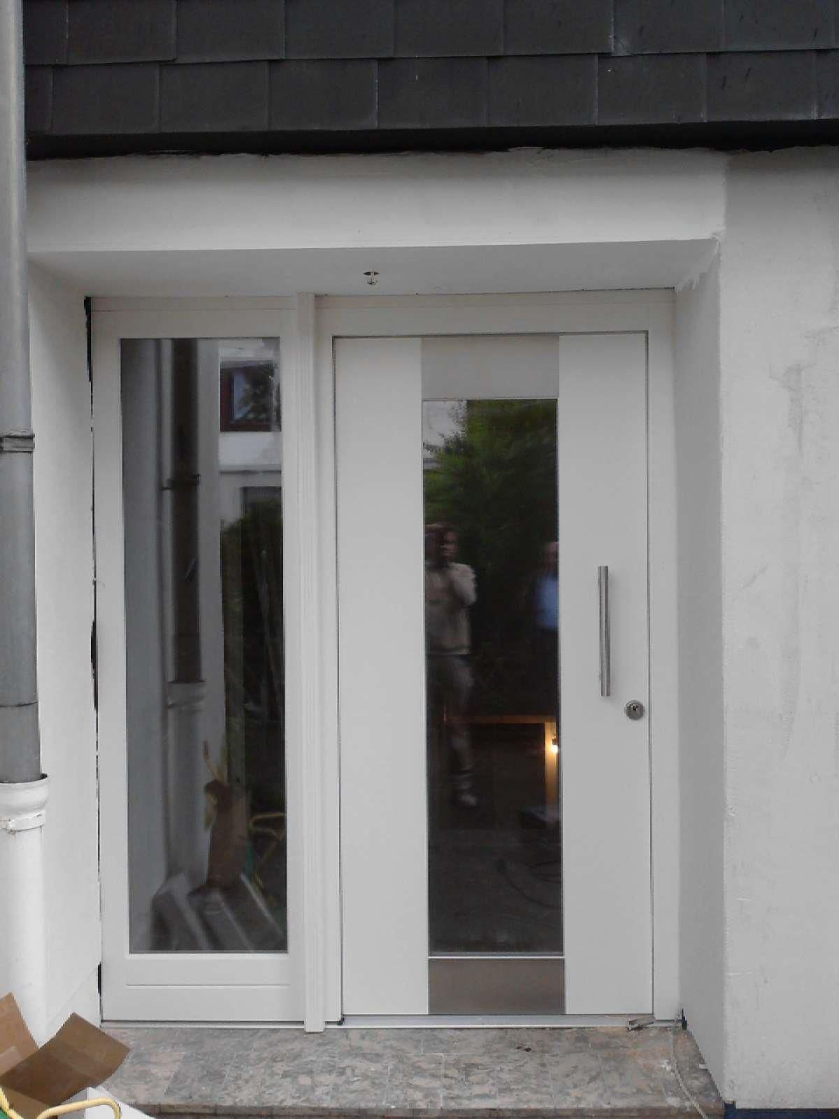 Eine weiße Tür mit der Spiegelung einer Person darin