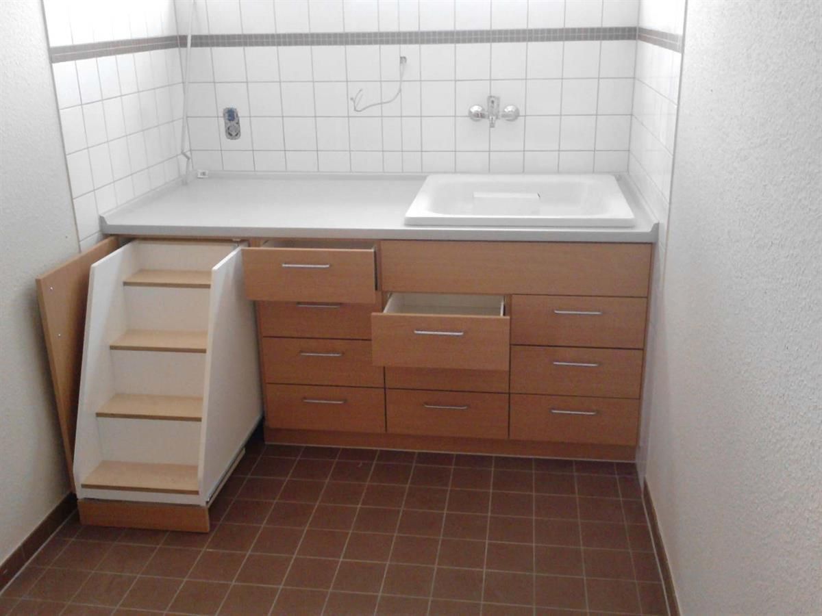 Ein Badezimmer mit Waschbecken, Schubladen und Treppe