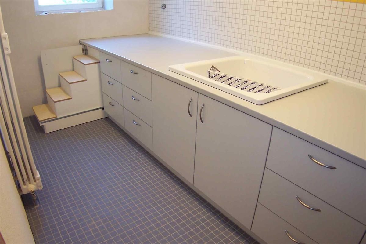 Eine Küche mit weißen Schränken und einer Spüle