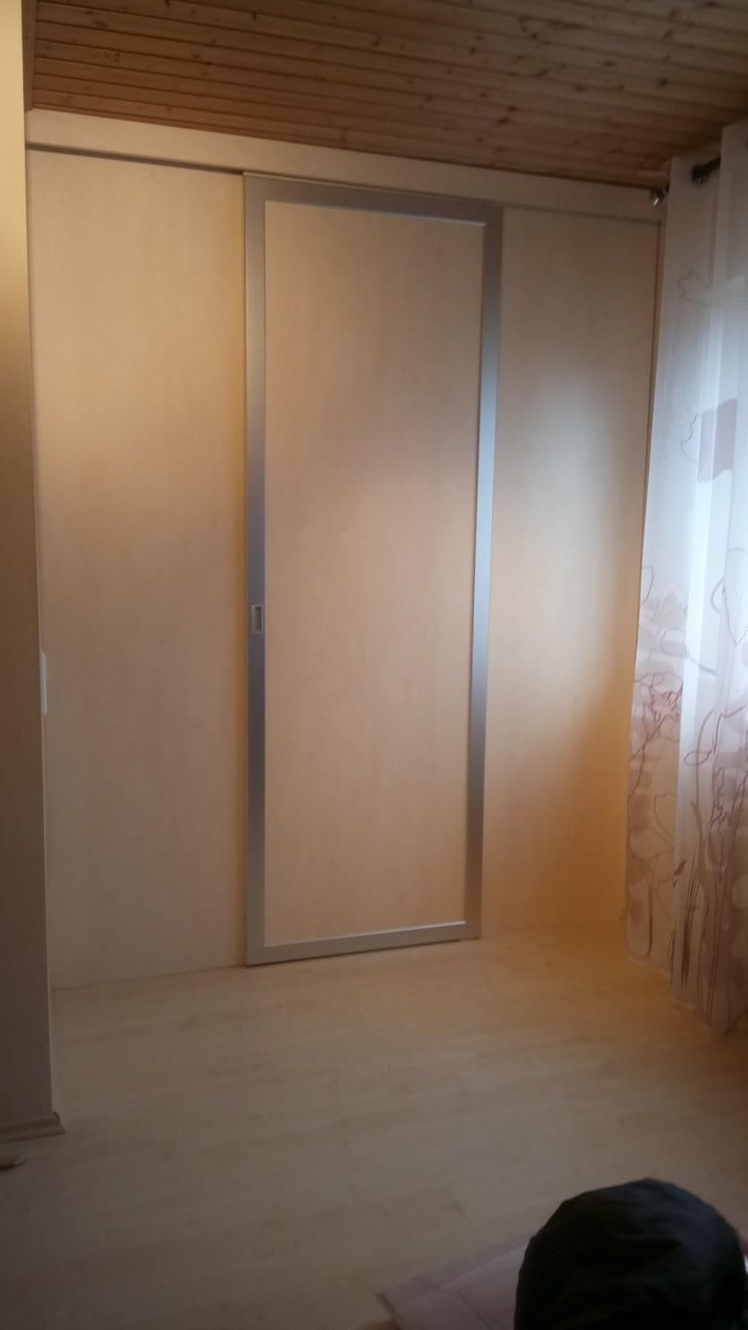 In der ecke des zimmers ist eine schiebetür.