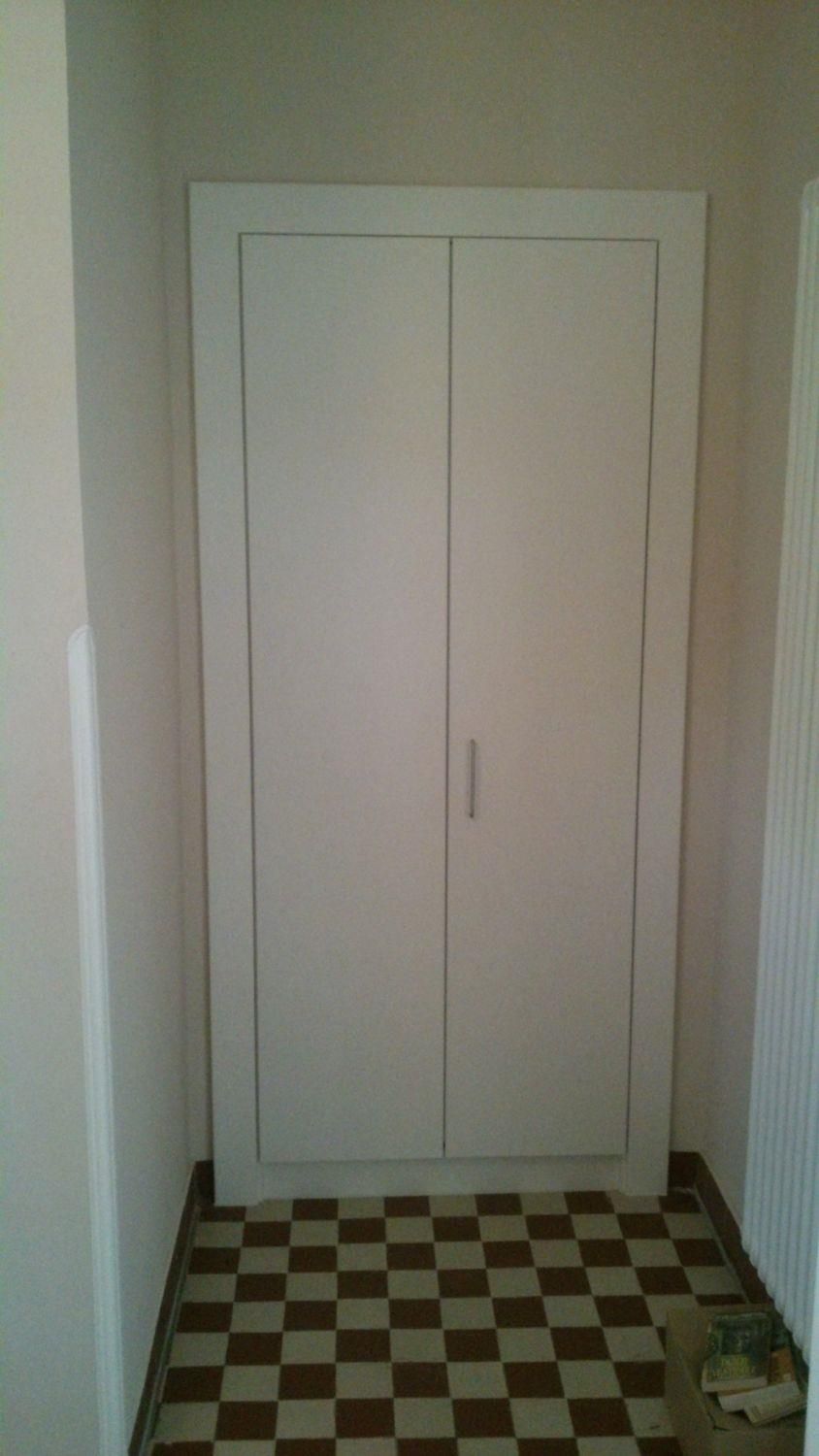 Ein Flur mit kariertem Boden und weißer Tür.