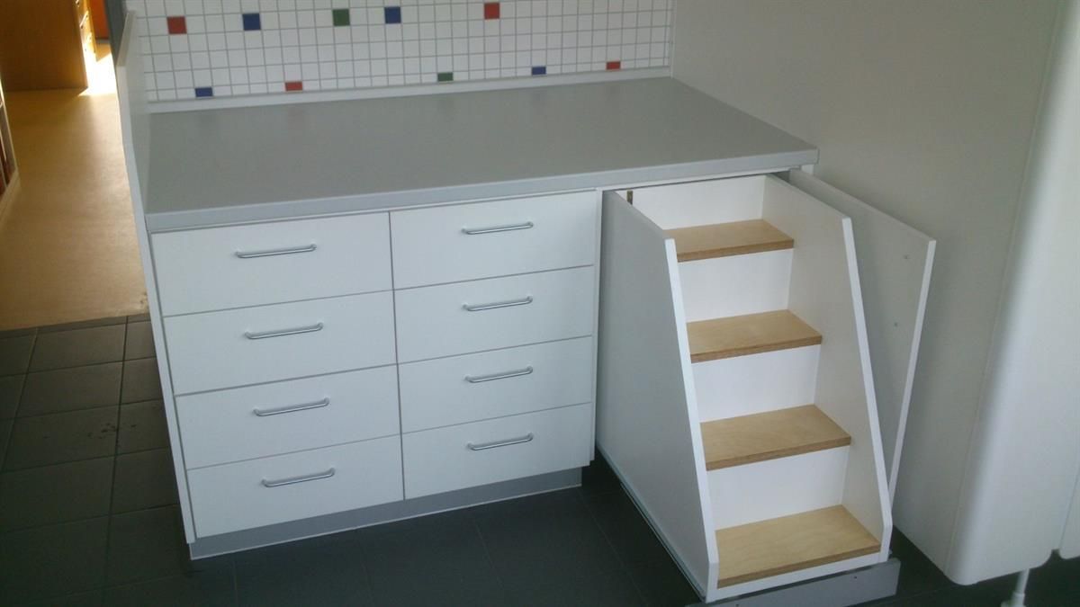 Ein weißer Schrank mit einer Treppe, die hinaufführt