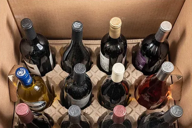 Caja de botellas de vino, varios colores, en embalaje protector de cartón.