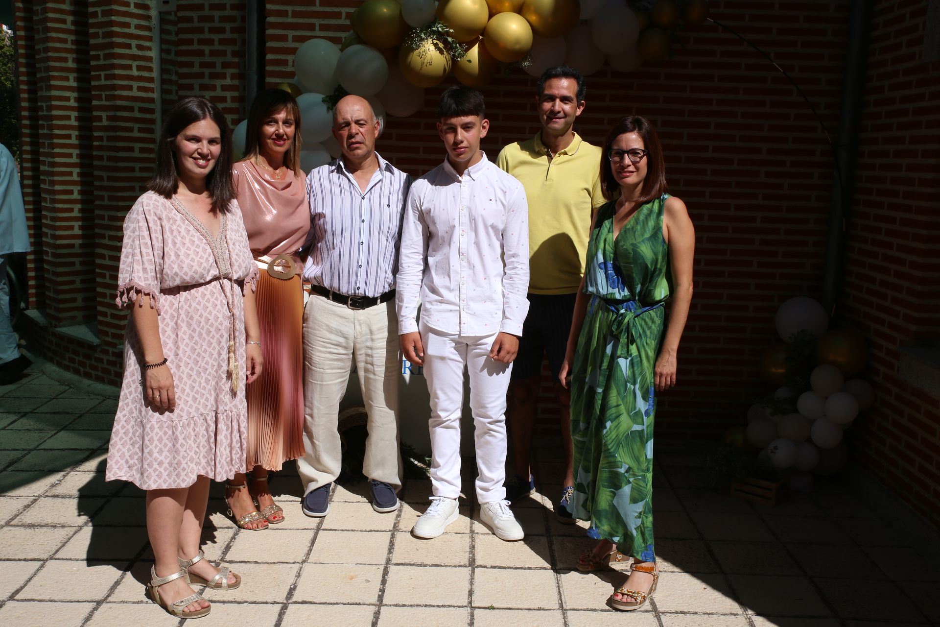Un grupo de personas posando para una foto con globos de fondo.