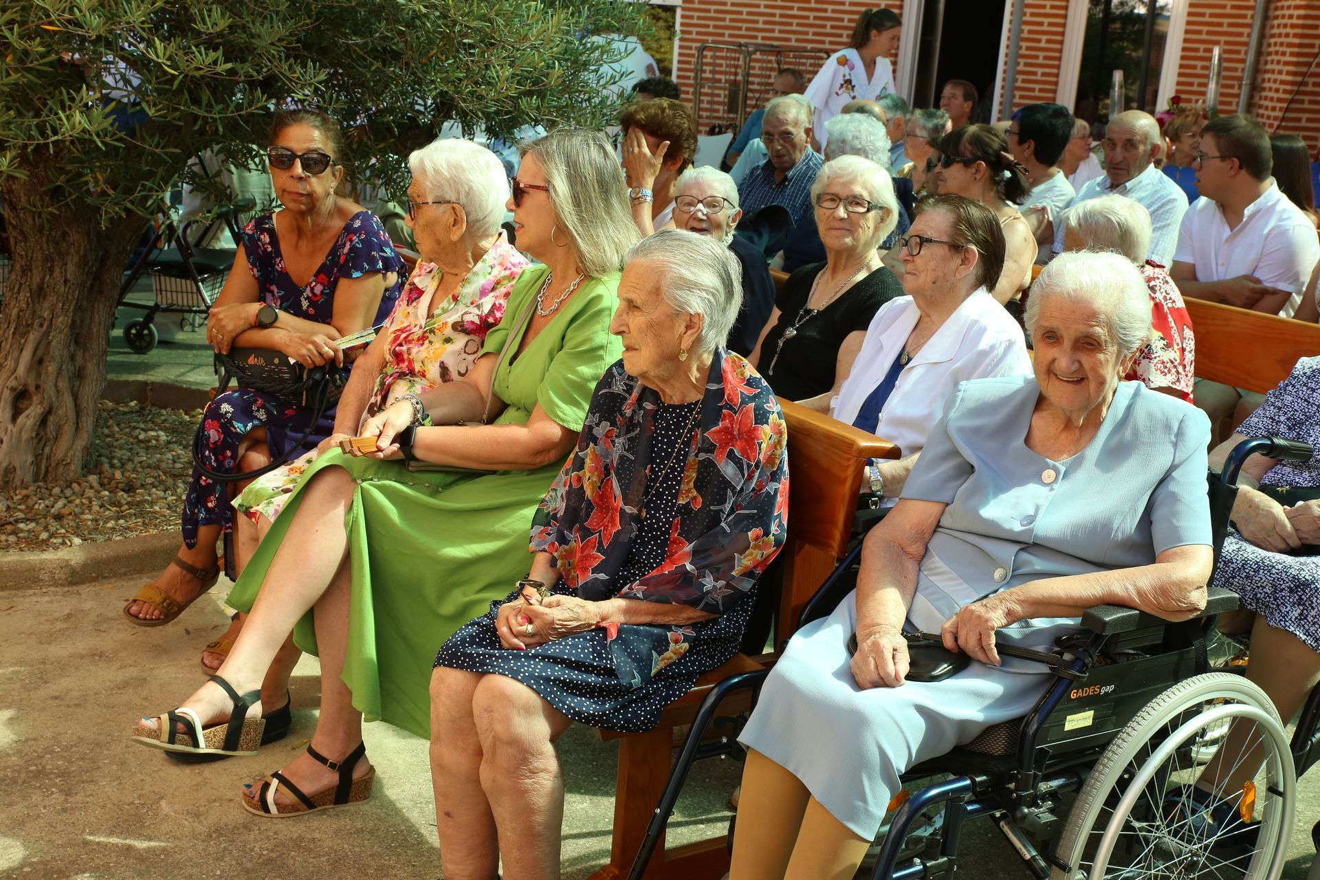 Un grupo de mujeres mayores están sentadas en un banco.