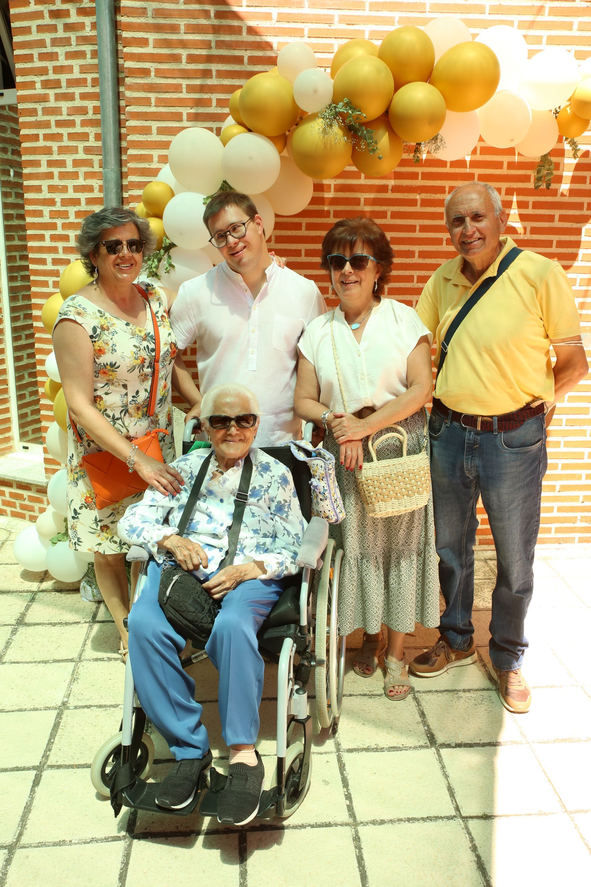 Un grupo de personas posando para una foto con una mujer en silla de ruedas.