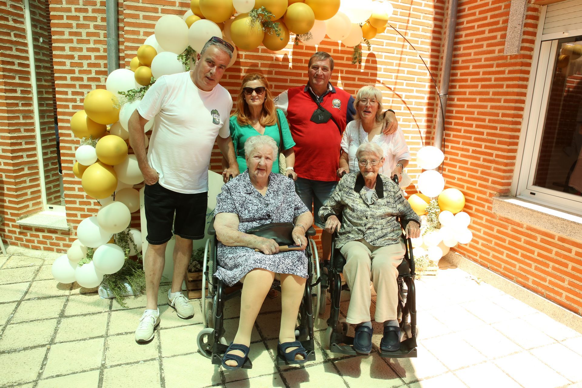 Un grupo de personas posando para una foto con una mujer en silla de ruedas.