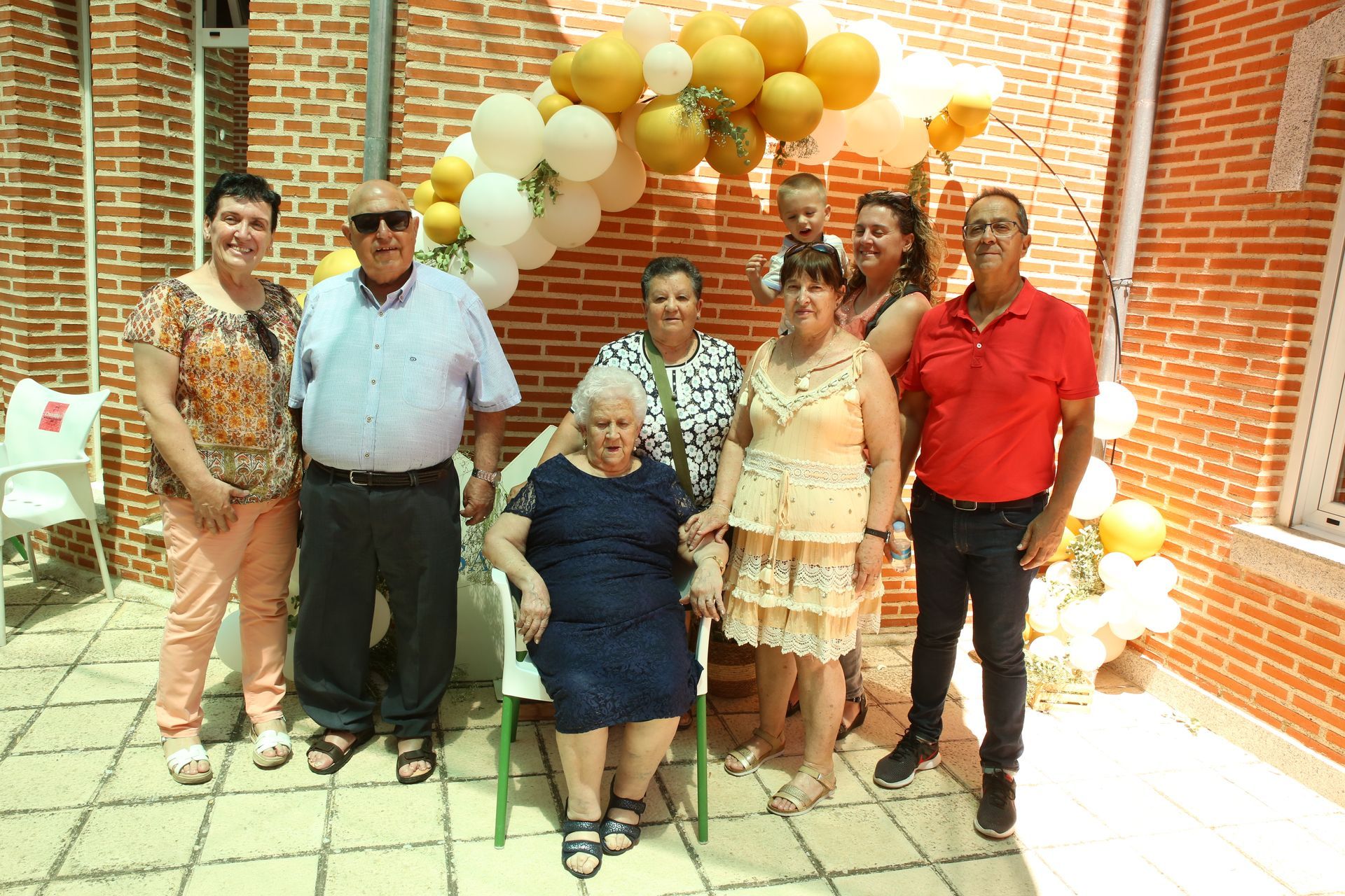 Un grupo de personas posando para una fotografía frente a una pared de ladrillos.