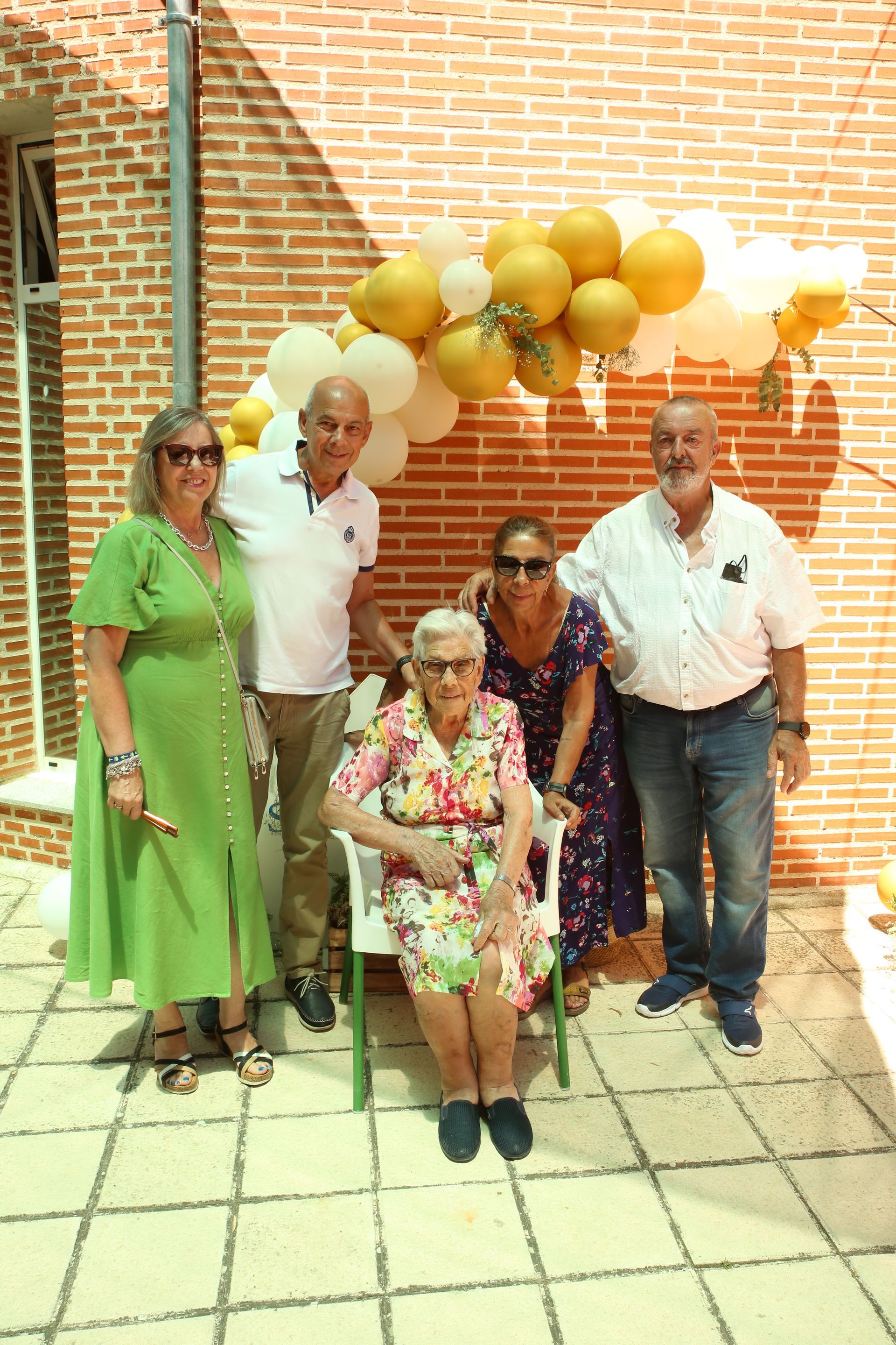 Un grupo de personas posando para una foto con globos de fondo.