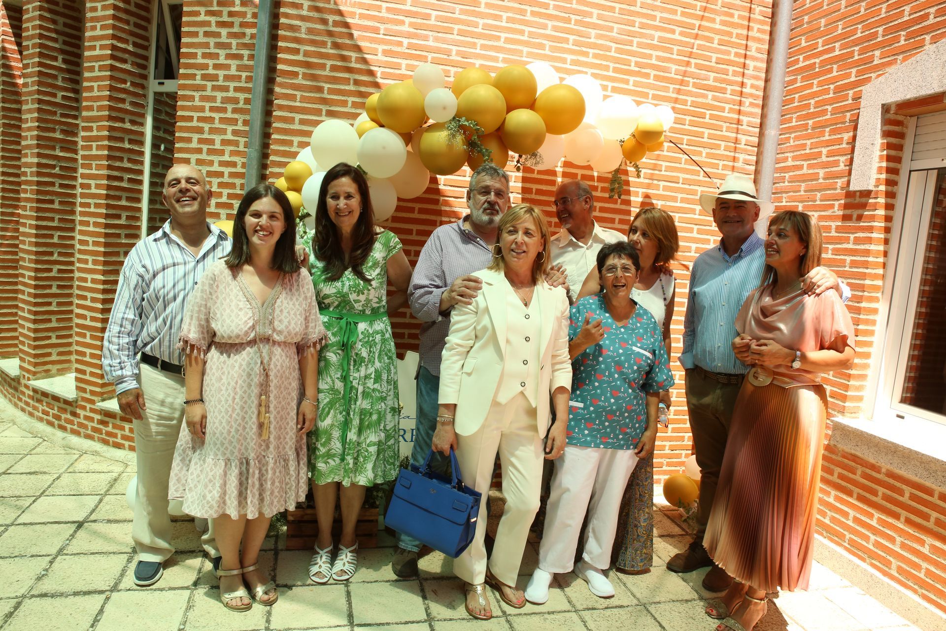 Un grupo de personas posando para una fotografía frente a una pared de ladrillos.