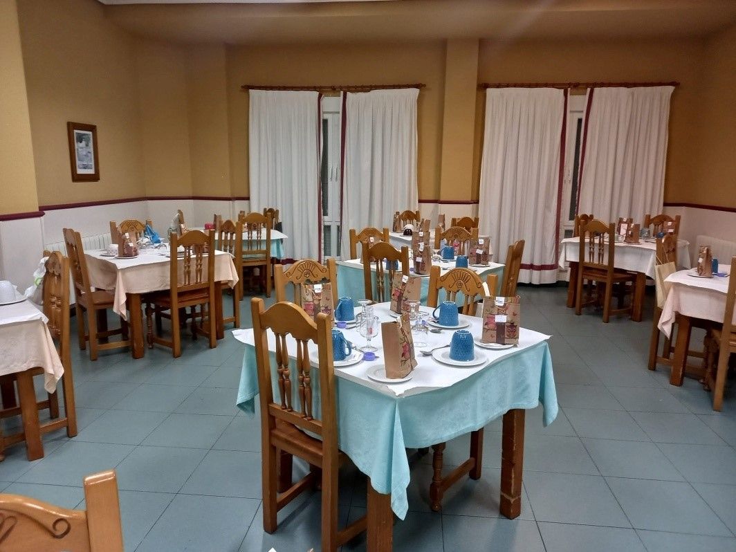 Un comedor con mesas y sillas y un cuadro en la pared.