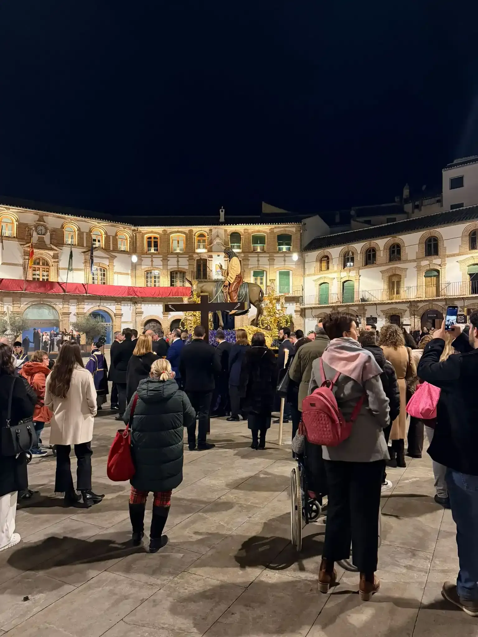 Una multitud se congregó de noche en una plaza iluminada