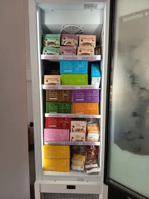 Congelador lleno de cajas de comida para mascotas de colores.