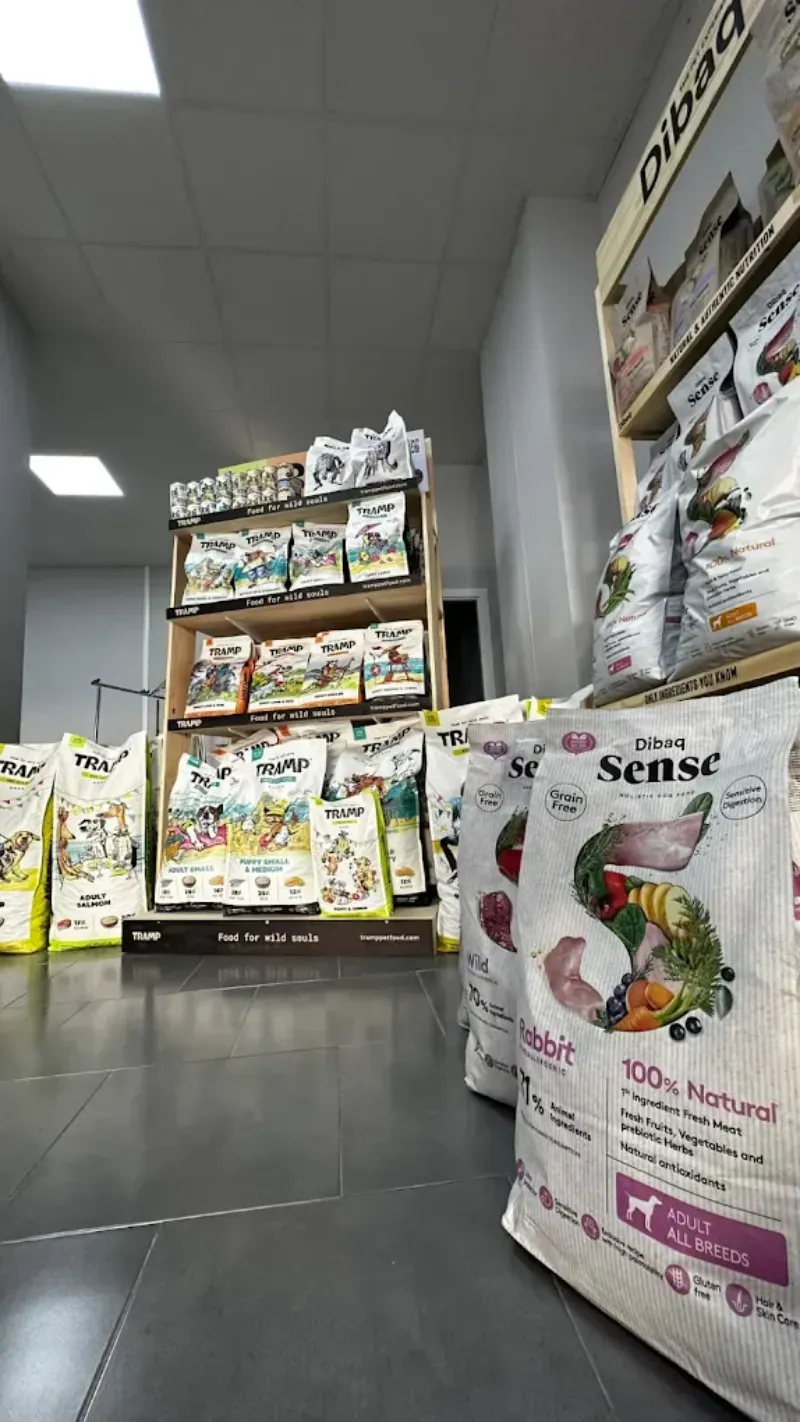 Bolsas de comida para mascotas y estantes en una tienda. Bolsas de color claro en primer plano.