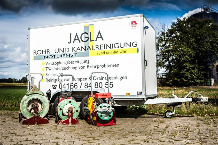 Weißer Jagla-Servicewagen mit Reinigungsgeräten, im Freien geparkt.