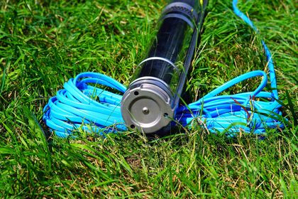 Une pompe et son tuyau sur de l'herbe