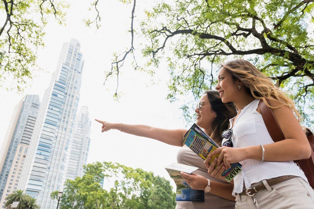 Dos mujeres miran un mapa y señalan un edificio.