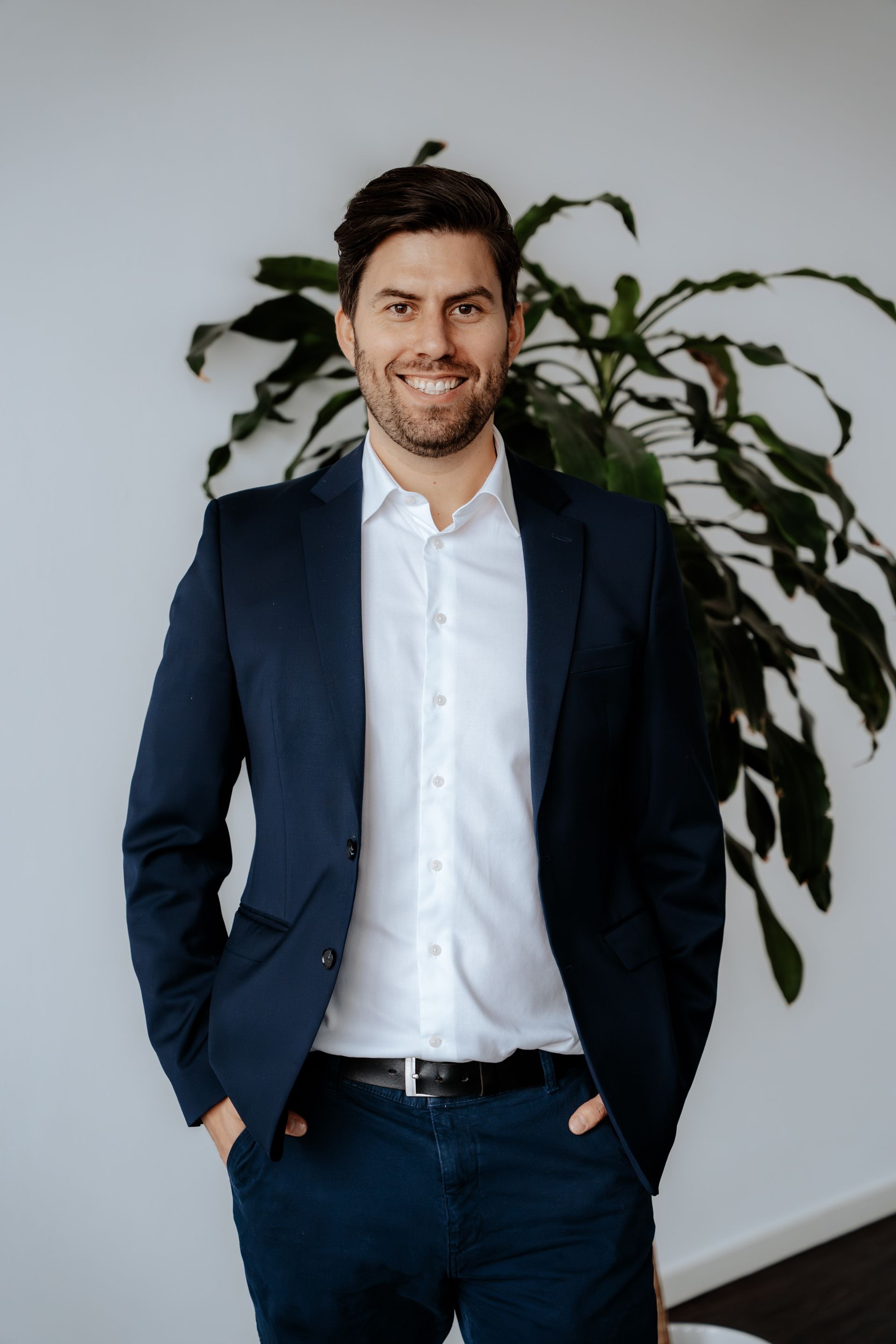 Eine Frau mit Brille und schwarzem Hemd hält ein Buch und lächelt.