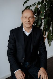 Ein Mann in einer Schürze kocht in einer Küche Essen in einer Bratpfanne.