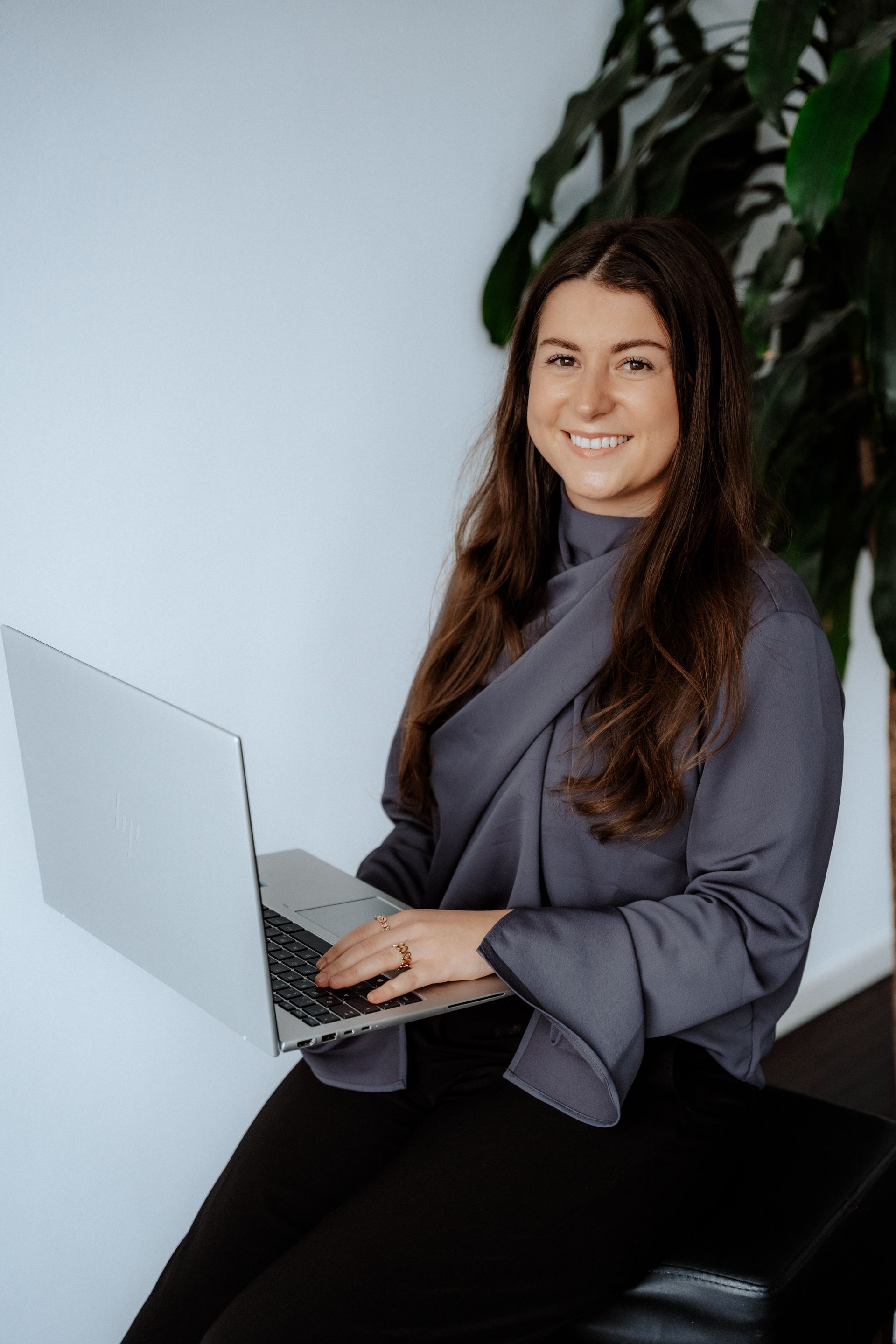 Eine Frau in einem schwarzen OP-Kittel hält einen Stapel weißer Handtücher.