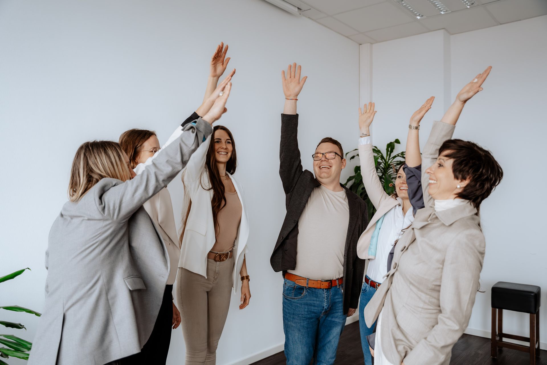Eine Gruppe von Leuten sitzt um einen Tisch herum und schaut auf einen Laptop.